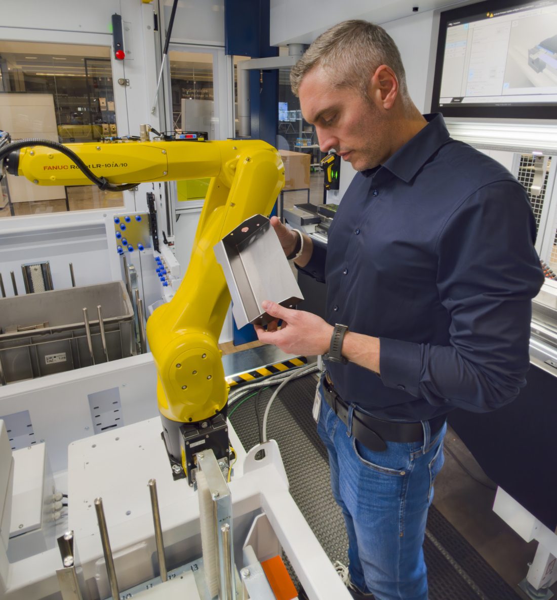 „In der Zelle“: Marc Unger, Operations Manager bei Blechnext, überprüft das mithilfe des Roboterarms in der Biegezelle automatisiert abgekantete Blechteil.